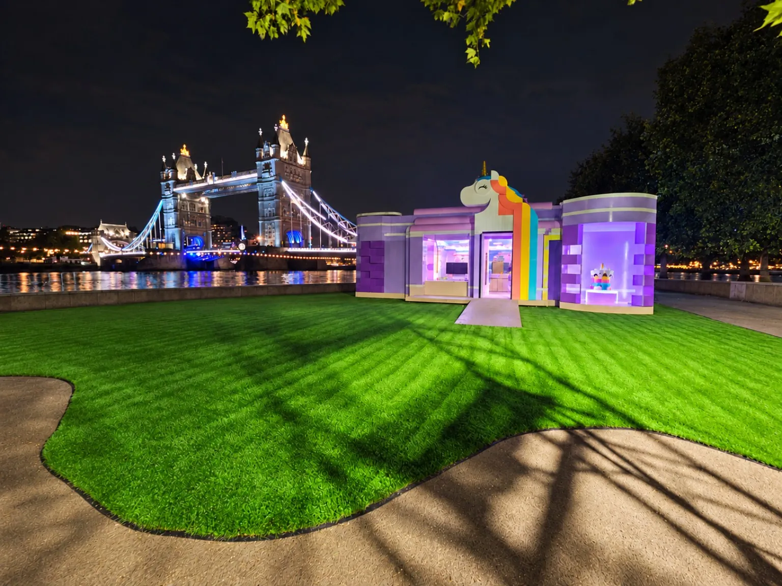 Saygrass temporary artificial grass around an illuminated event pavilion beside Tower Bridge
