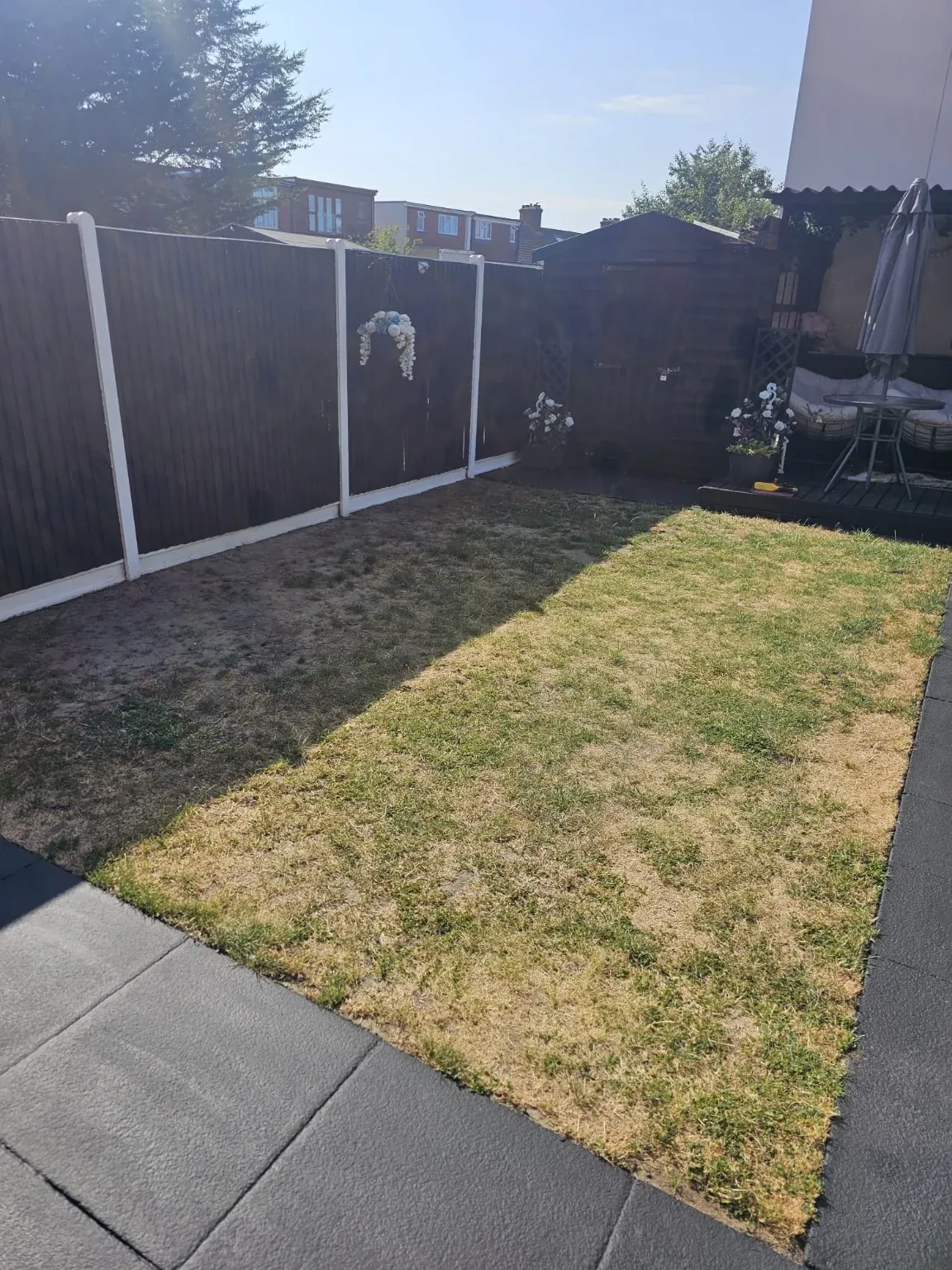 Before installation: the same garden with a worn natural lawn